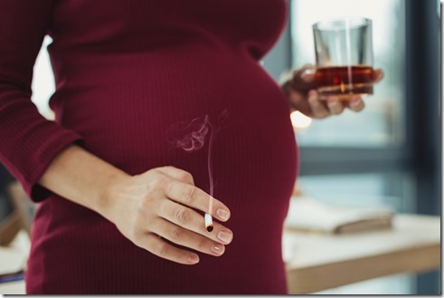 Irresponsible pregnant woman smoking and drinking alcohol