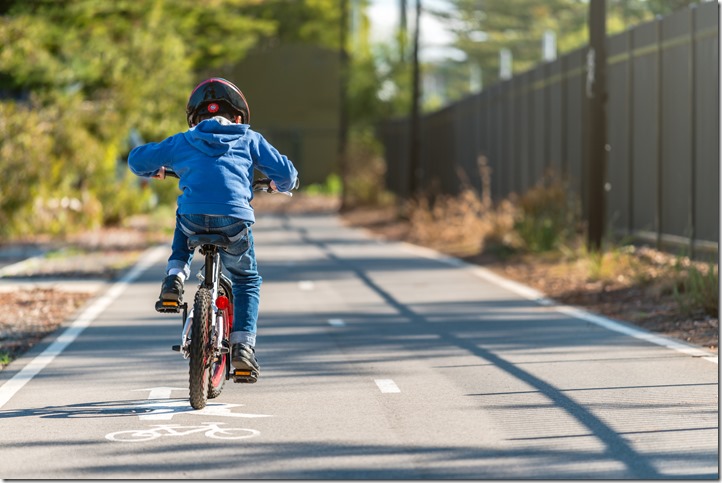 Kid riding his bicycle on bike lane