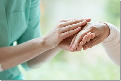 Caretaker massaging pensioner's hand