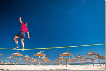 Young man doing slackline on the beautiful summer tropical beach. Active life sport photo