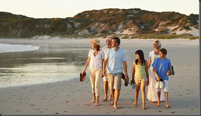 Seis integrantes de familia multigeneracional caminan en la playa