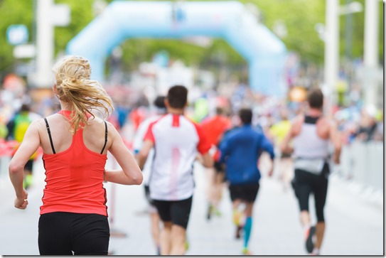 Woman running at marathon at start / finish