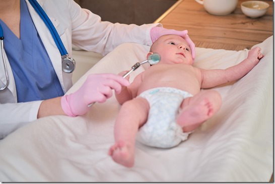 A doctor in uniform checks a child mouth with a mirror. Dentist examines the teeth of a newborn baby
