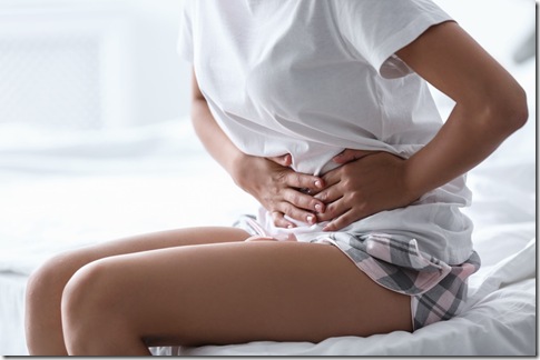 Young woman suffering from menstrual cramps at home. Gynecology