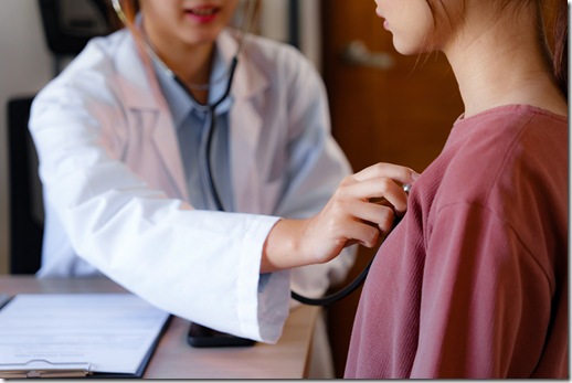 Doctor using stethoscope to check the heartbeat of the patient
