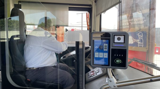 Comerciante de barrio recibiendo información sobre el nuevo sistema de pago electrónico Bipay en el transporte público