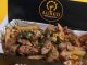 Plato de papas fritas gourmet con salsas especiales en el nuevo local Aureo Fries