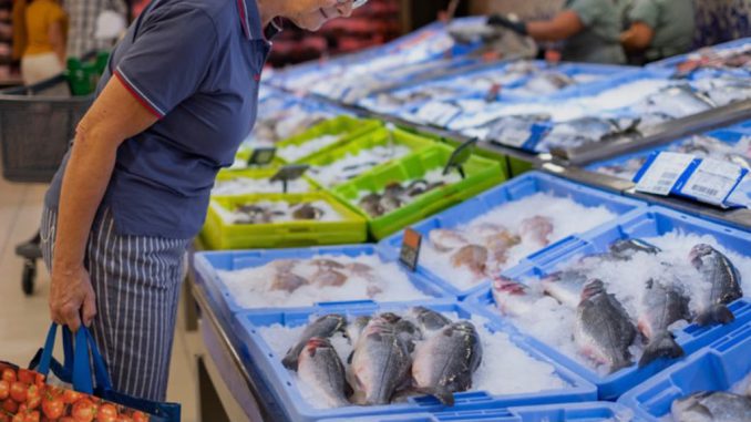 Variedad de pescados y mariscos frescos en un mercado chileno para promover su consumo nacional.