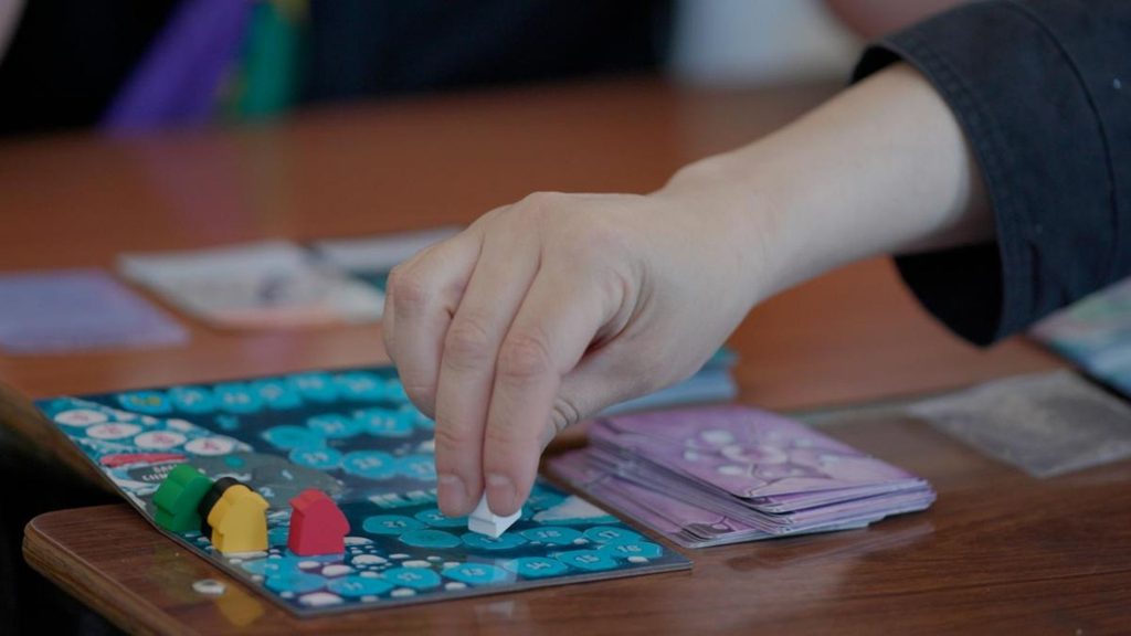 Jugadores participando en una partida competitiva del juego de mesa ILAN sobre la Antártica