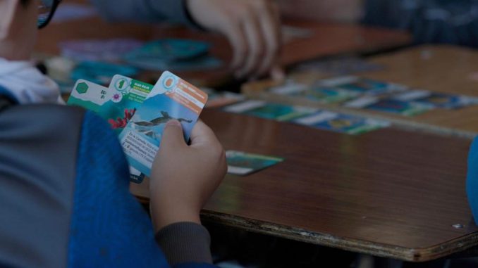 Jugadores participando en una partida competitiva del juego de mesa ILAN sobre la Antártica