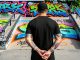 Joven realizando un grafiti en una zona prohibida como advertencia de conductas de riesgo