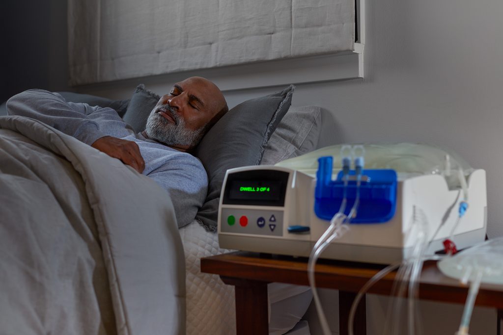 Paciente realizándose una sesión de diálisis peritoneal en su hogar