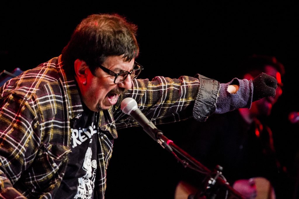 Mauricio Redolés actuando en vivo con su banda en el escenario del Teatro Mauri