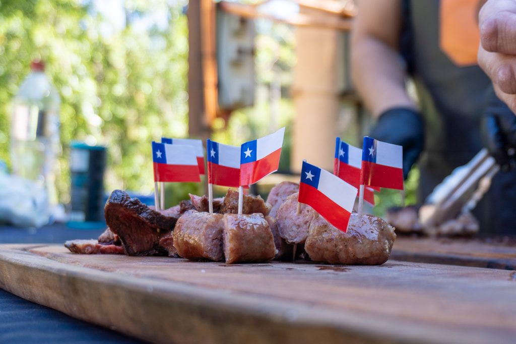 Personas disfrutando de gastronomía chilena y música en la Feria Sobremesa durante las Fiestas Patrias