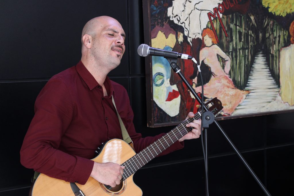 Poetas y músicos participando en una presentación cultural en la librería La Flor de Papel en Valparaíso